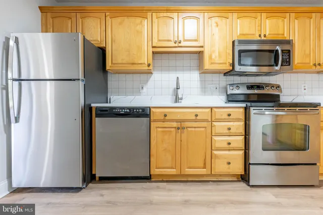 a kitchen with granite countertop a refrigerator stove and microwave