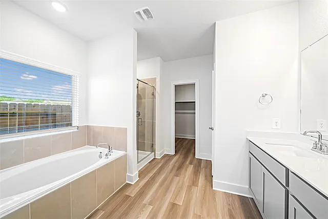 a view of a livingroom with a ceiling fan & windows