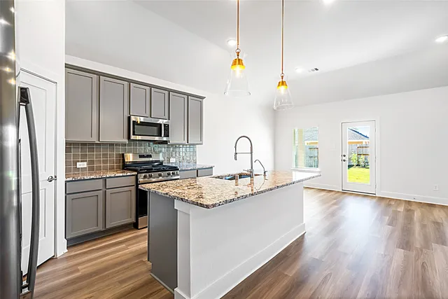 a kitchen with a sink a stove a refrigerator and a microwave