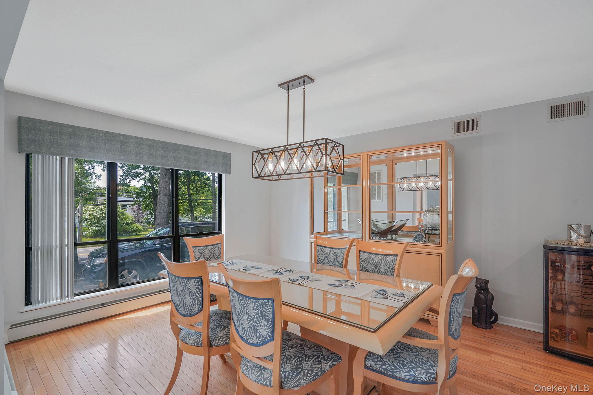 318 Sheep Pasture Road East Setauket, NY 11733 - Photo 12 of 45 a dining room with furniture a chandelier and wooden floor
