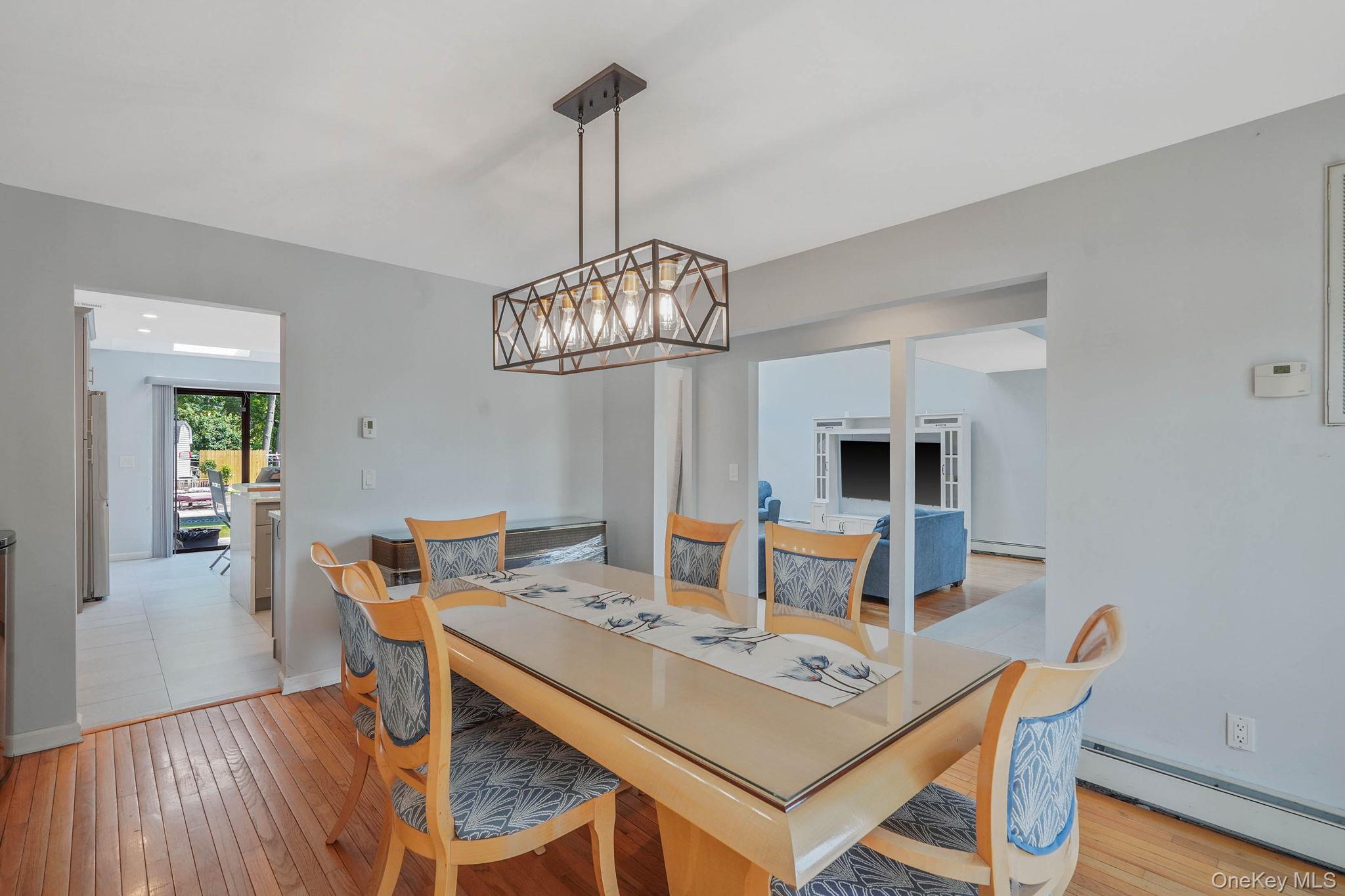 318 Sheep Pasture Road East Setauket, NY 11733 - Photo 13 of 45 a view of a dining room with furniture wooden floor and chandelier