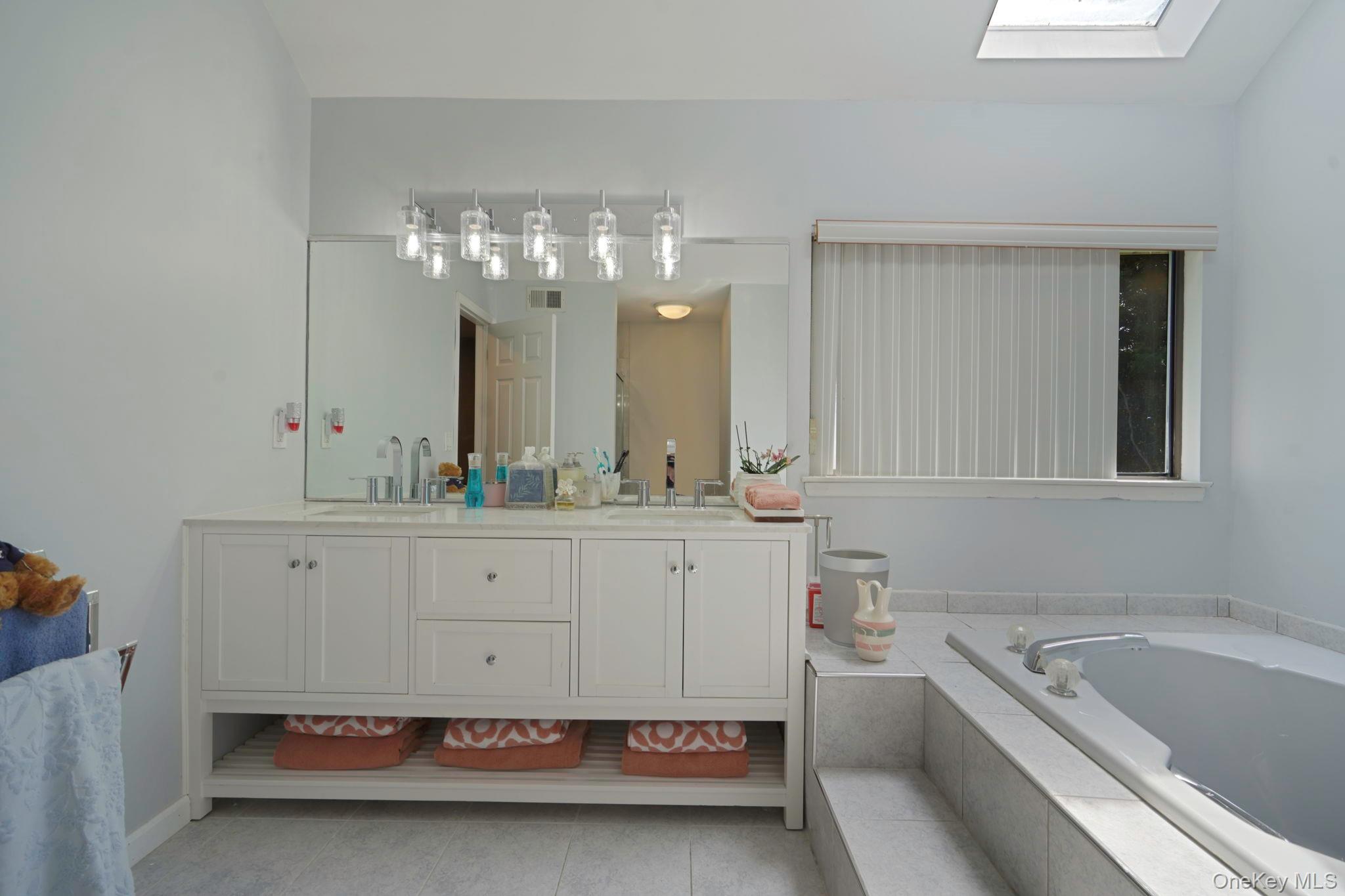 318 Sheep Pasture Road East Setauket, NY 11733 - Photo 20 of 45 a spacious bathroom with a tub double sink and mirror