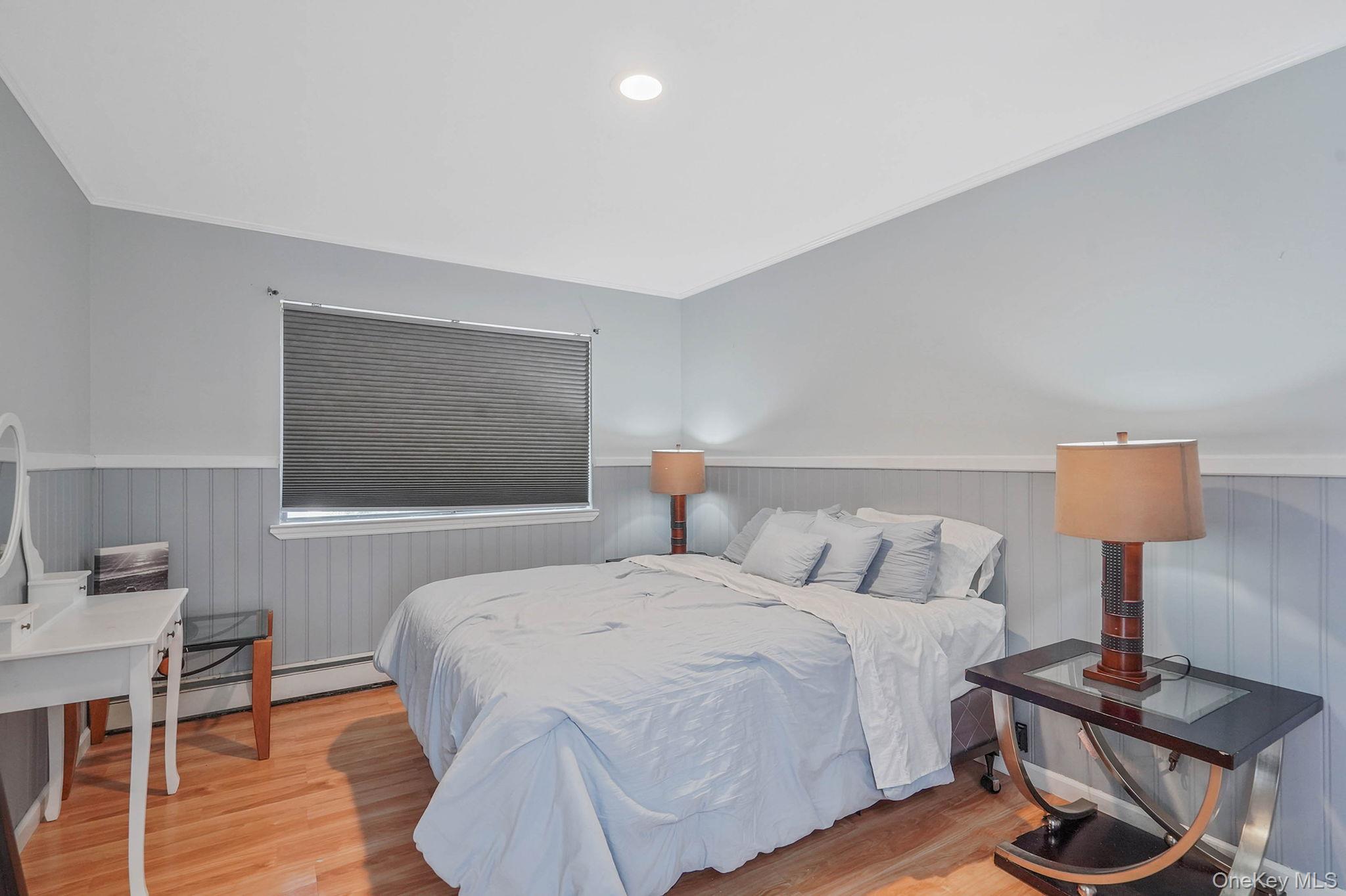 318 Sheep Pasture Road East Setauket, NY 11733 - Photo 26 of 45 a bedroom with a bed and wooden floor