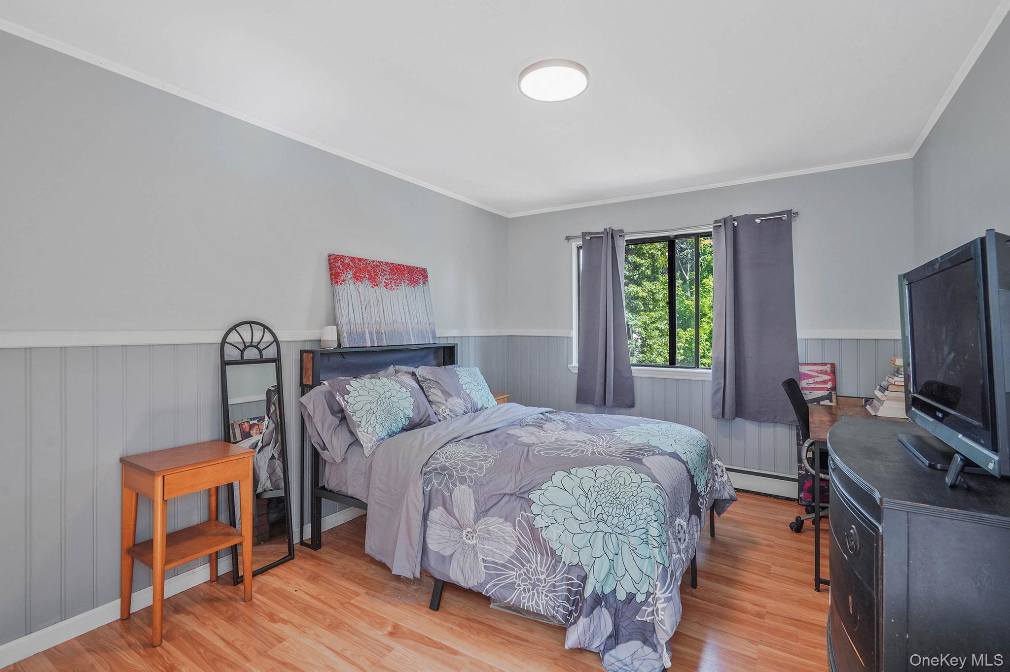 318 Sheep Pasture Road East Setauket, NY 11733 - Photo 28 of 45 a bedroom with a bed and a flat screen tv