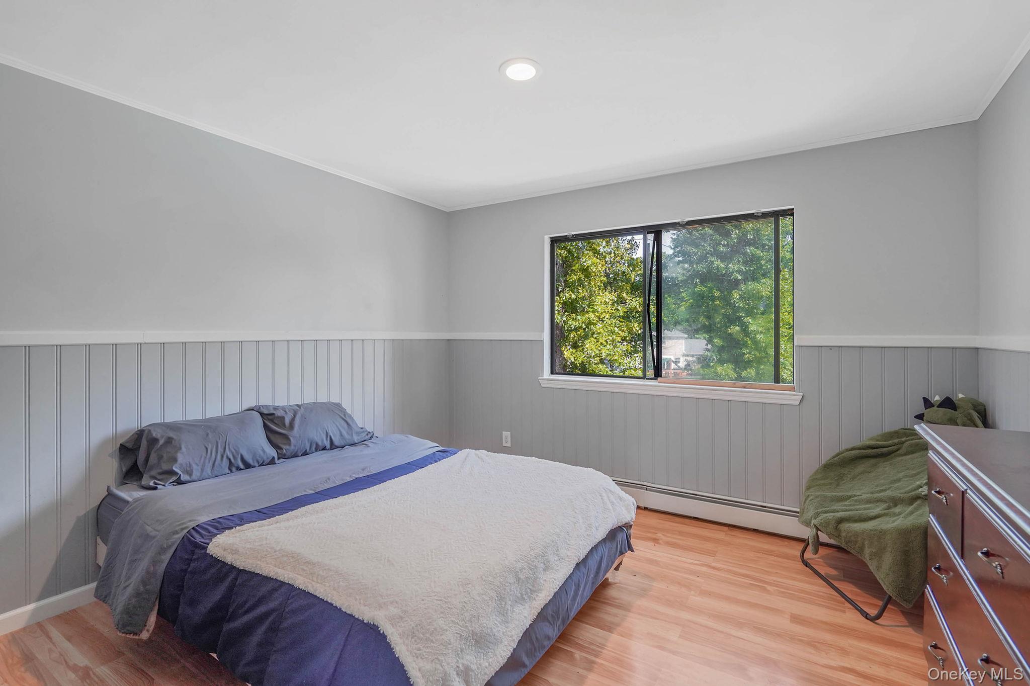 318 Sheep Pasture Road East Setauket, NY 11733 - Photo 30 of 45 a bedroom with a bed and wooden floor