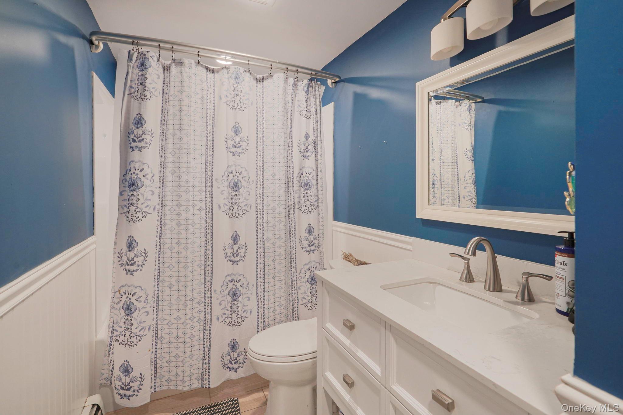 318 Sheep Pasture Road East Setauket, NY 11733 - Photo 36 of 45 a bathroom with a sink a toilet and shower curtain