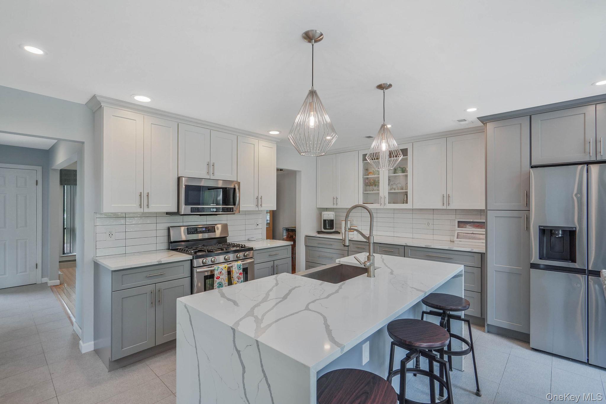 318 Sheep Pasture Road East Setauket, NY 11733 - Photo 7 of 45 a kitchen with appliances a sink and chairs