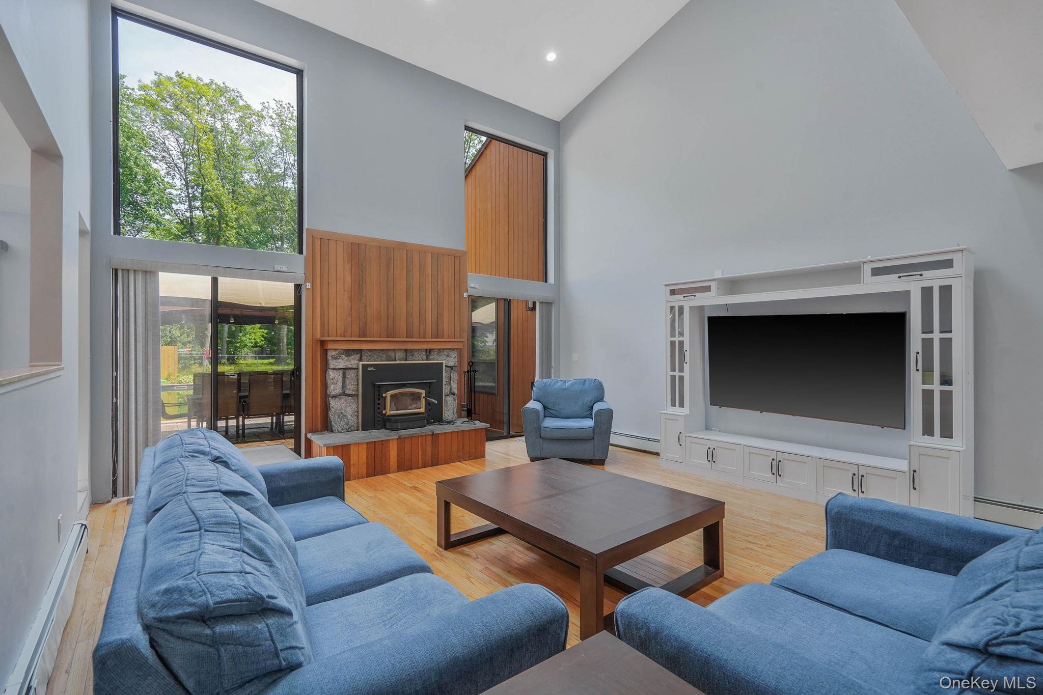 318 Sheep Pasture Road East Setauket, NY 11733 - Photo 10 of 45 a living room with furniture a large window and a fireplace