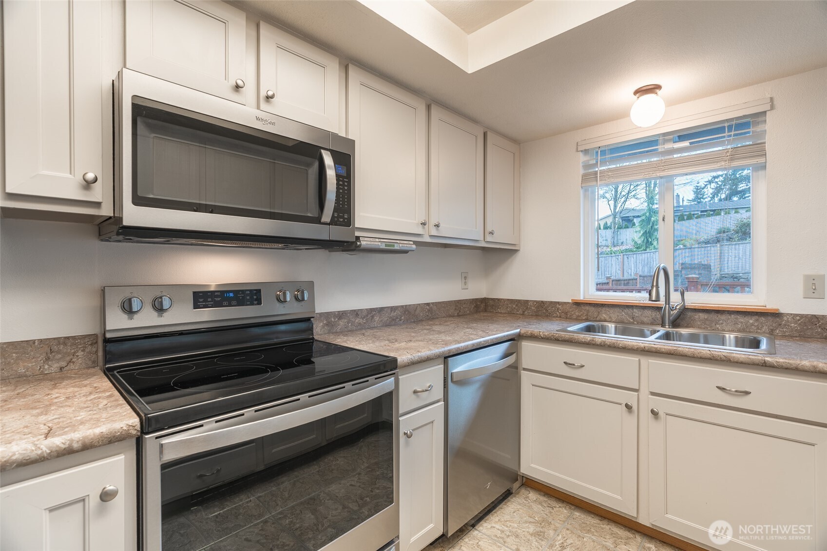 14031 33rd Place South Tukwila, WA 98168 - Photo 13 of 37 a kitchen with granite countertop a stove microwave and sink