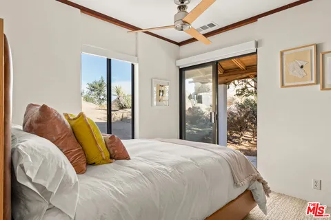 a bedroom with a bed and a large window