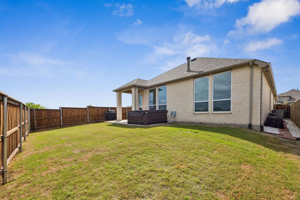 2430 Brightling Bend Forney, TX 75126 - Photo 31 of 37 Rear view of property featuring a hot tub, a patio, brick siding, a fenced backyard, and a shingled roof