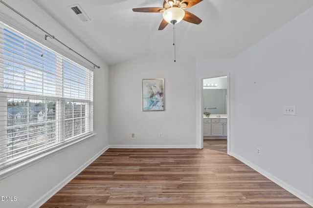 a view of a livingroom with wooden floor and a ceiling fan