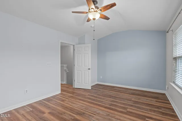 a view of a room with wooden floor and a ceiling fan