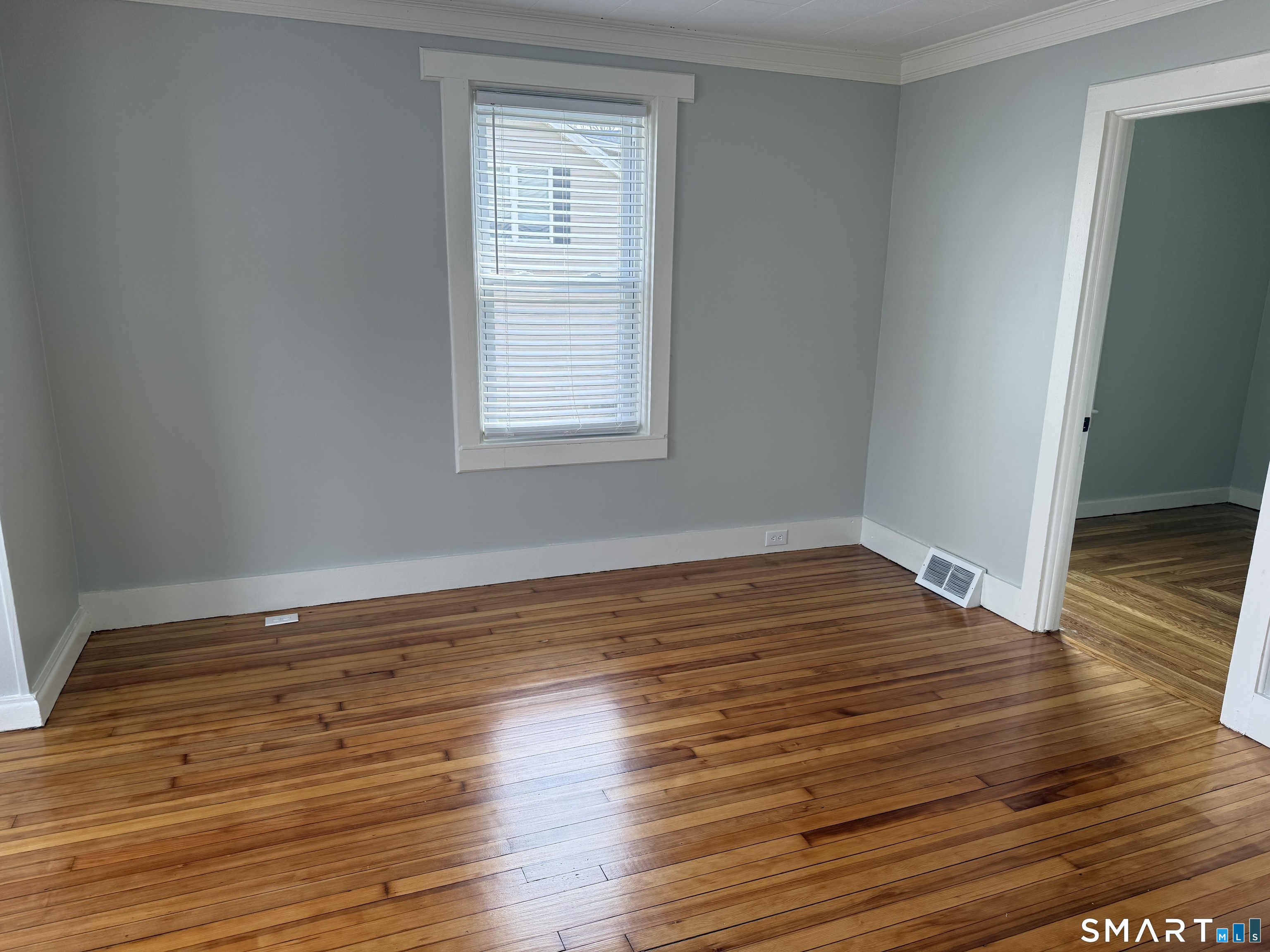 159 Hickory Street Norwich, CT 06360 - Photo 3 of 7 a view of empty room with wooden floor and fan