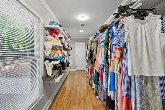 a view of walk in closet with clothes and shoes