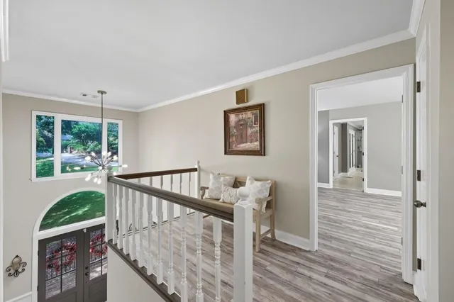 a view of a hallway with wooden floor and stairs