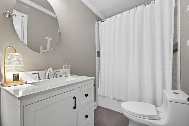 a bathroom with a sink a toilet and shower curtain
