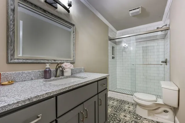 a bathroom with a granite countertop sink toilet and shower