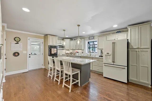 a kitchen with stainless steel appliances granite countertop a refrigerator and a stove top oven