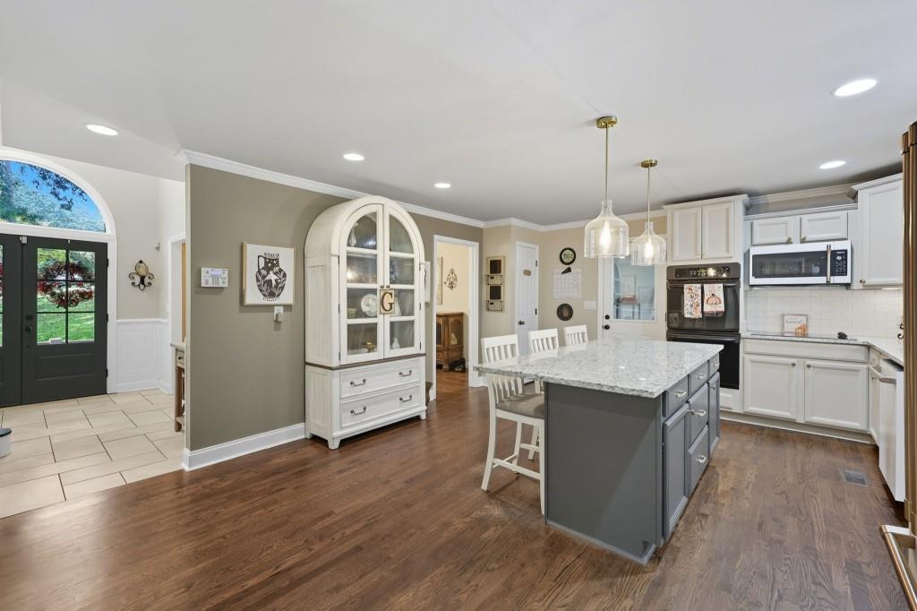 3810 Hardy Place Gainesville, GA 30506 - Photo 4 of 34 a large kitchen with stainless steel appliances kitchen island granite countertop a lot of cabinets and wooden floor