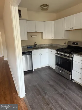 a kitchen with granite countertop a sink and a stove top oven