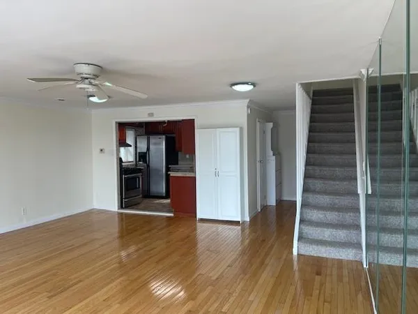 a view of a room with wooden floor and ceiling fan