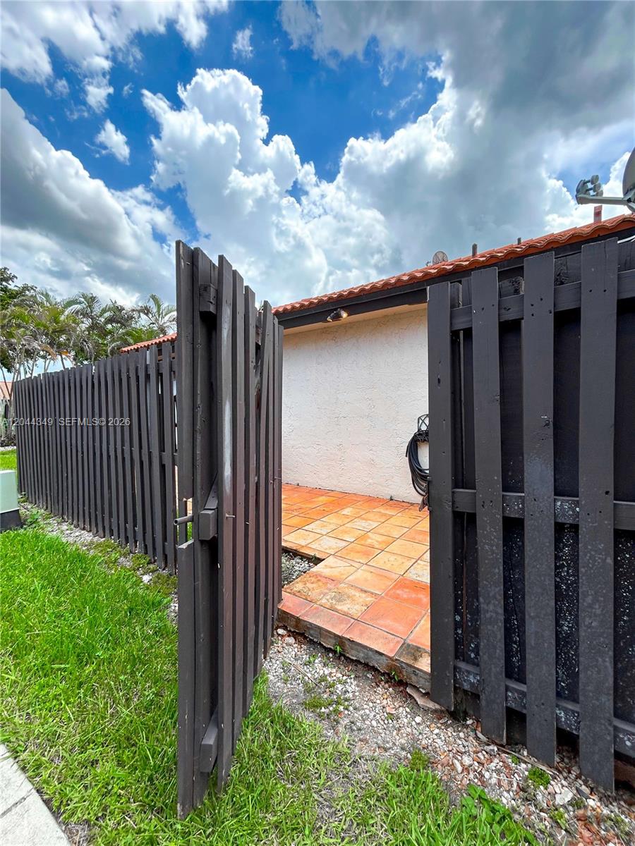 14970 Southwest 48th Terrace, Unit 27G Miami, FL 33185 - Photo 10 of 14 a backyard of a house with wooden fence