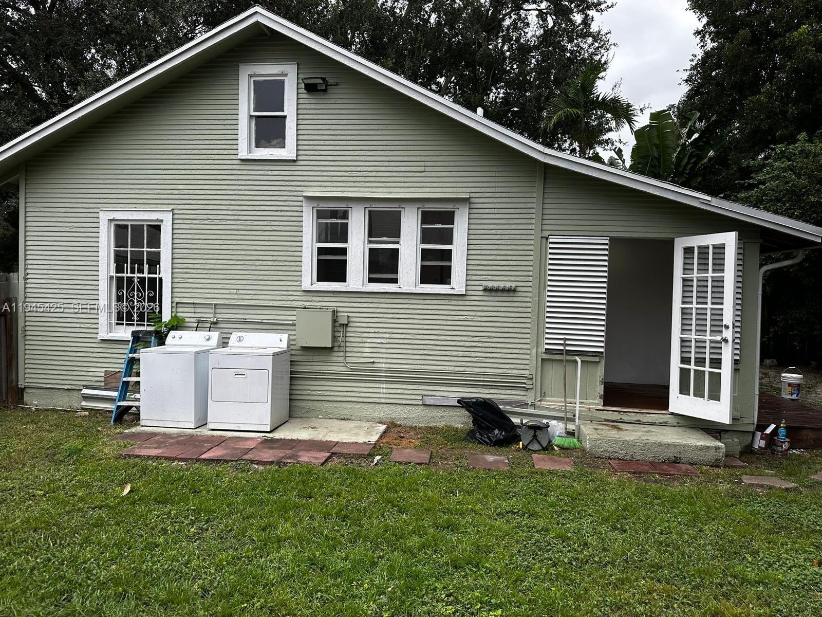 4116 Southwest 13th Terrace Miami, FL 33134 - Photo 7 of 8 a view of a house with a yard chairs and a large tree