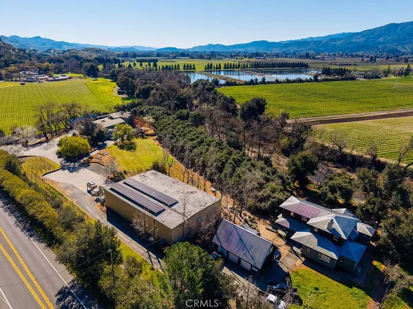 aerial view of a house with a garden and lake view