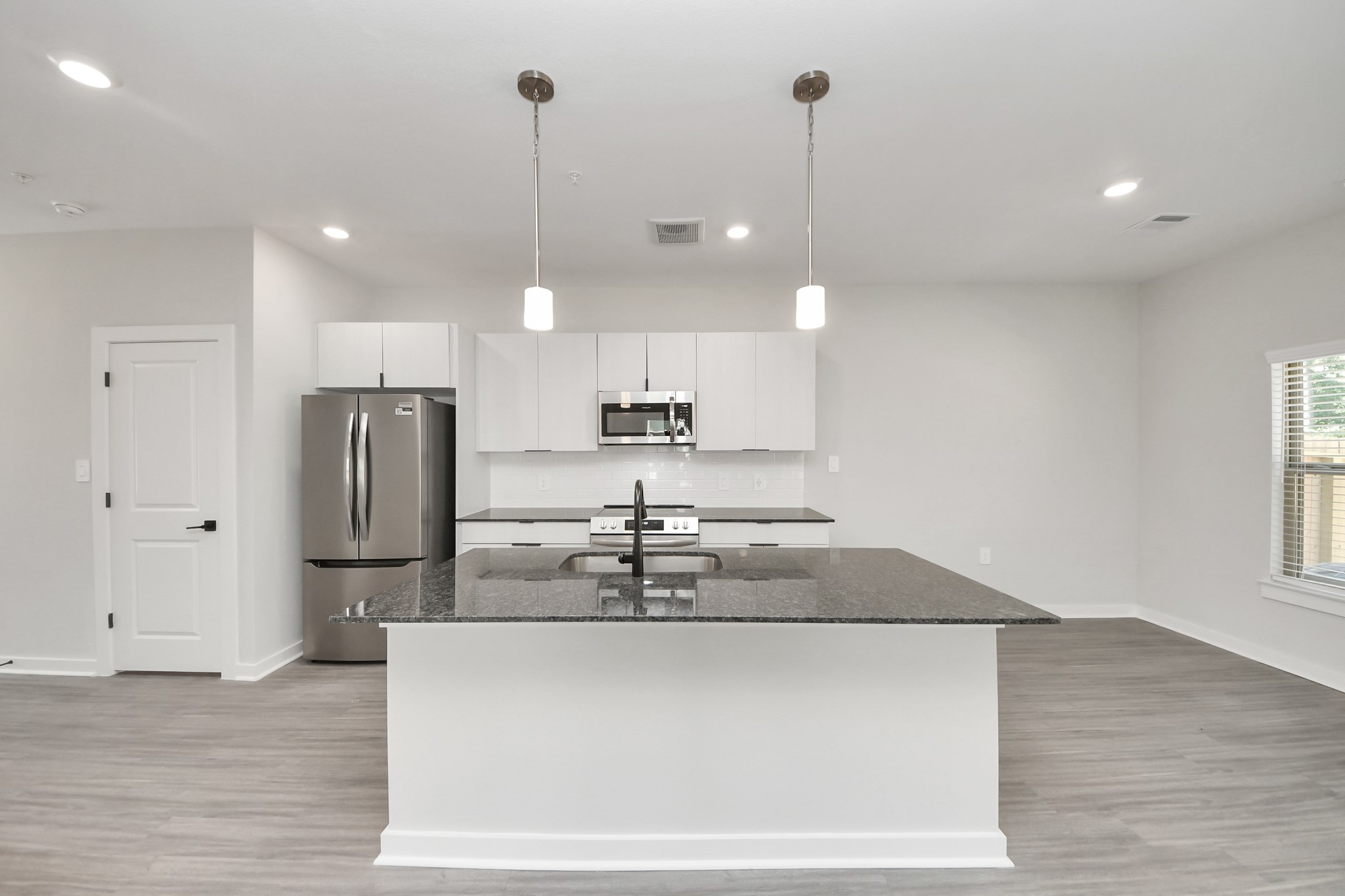 7711 Longmire Road, Unit 195 Conroe, TX 77304 - Photo 39 of 48 Boasting luxury finishes-stylish Island kitchen,granite counters,subway tile backsplash,ample custom cabinet space,stainless appliances,refrigerator,full size washer&dryer included,wood-like floors throughout,open concept floor plan.