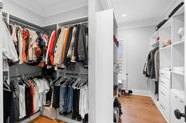a view of walk in closet with clothes and shoes