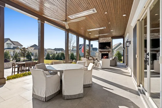 a view of a patio with dining table and chairs with plants and palm trees
