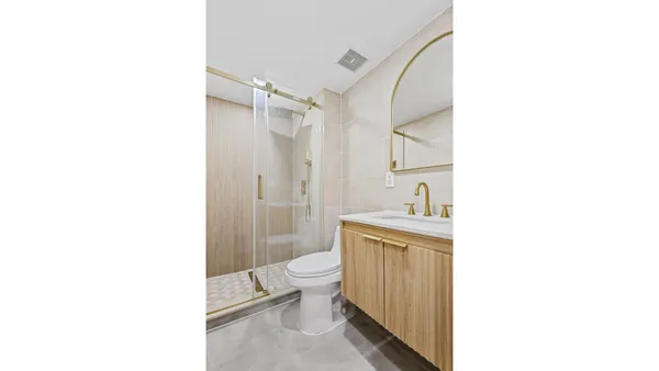 a bathroom with a sink a toilet and shower