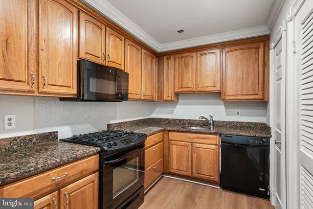 a kitchen with granite countertop stainless steel appliances a stove a sink and a microwave