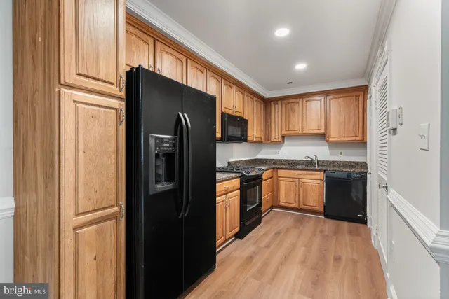 a kitchen with stainless steel appliances granite countertop a refrigerator stove top oven and sink