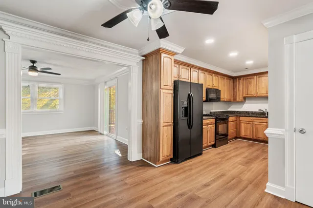 a kitchen with stainless steel appliances kitchen island granite countertop a refrigerator and a stove top oven