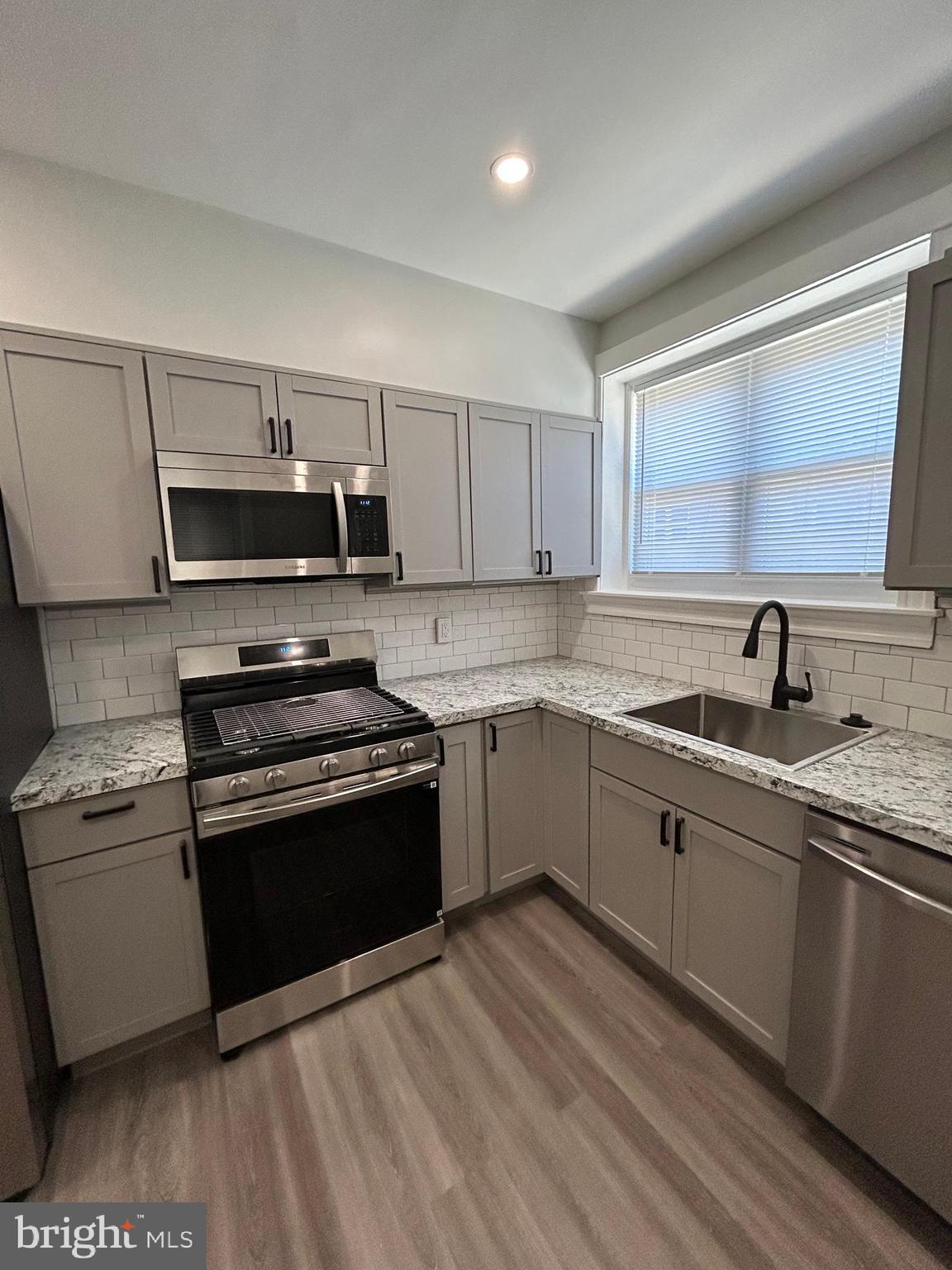 46 Lamport Road Upper Darby, PA 19082 - Photo 16 of 33 a kitchen with stainless steel appliances granite countertop a stove a sink and a microwave