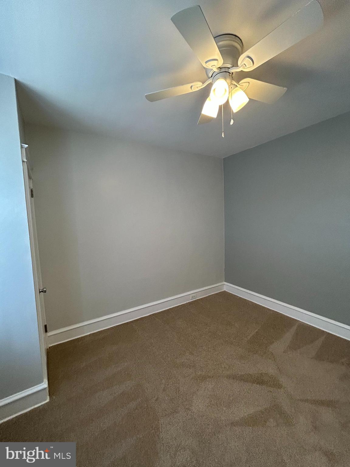 46 Lamport Road Upper Darby, PA 19082 - Photo 19 of 33 an empty room with a chandelier fan and windows
