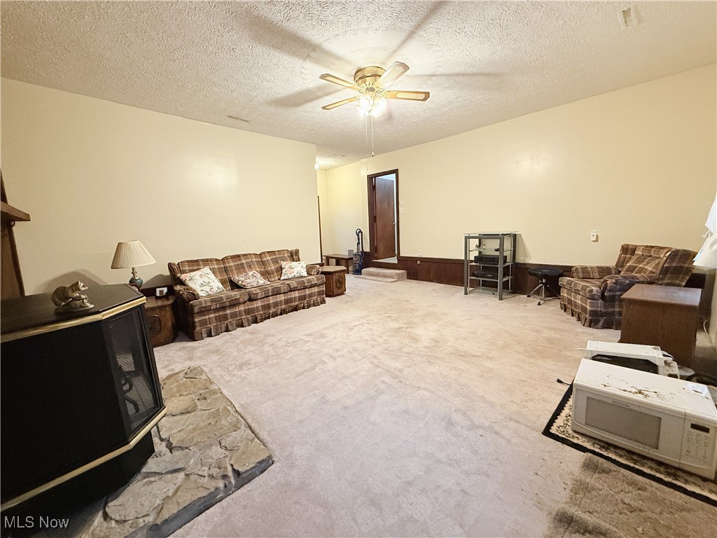 4185 Tapper Road Barberton, OH 44203 - Photo 15 of 23 Carpeted family area featuring a ceiling fan and a textured ceiling