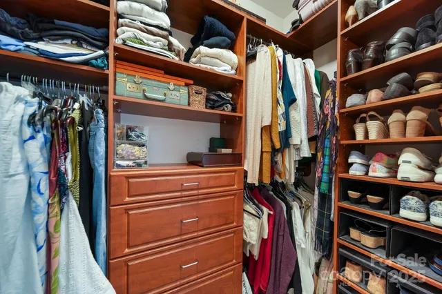 a view of walk in closet with clothes and shoes