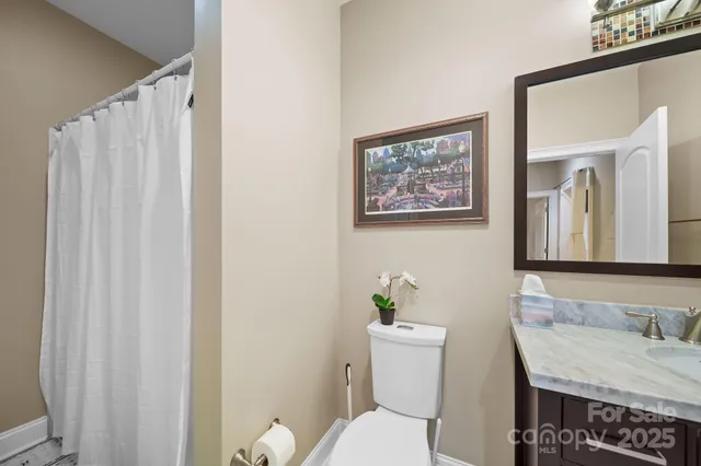 a bathroom with a granite countertop sink and a toilet