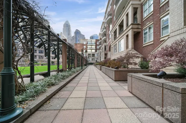a view of a pathway that has flowers in front of buildings