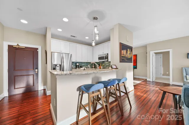 a kitchen with stainless steel appliances granite countertop a refrigerator and microwave