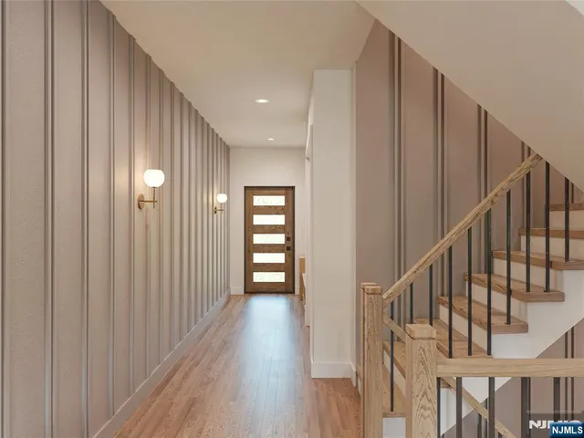 a view of a hallway with wooden floor and staircase
