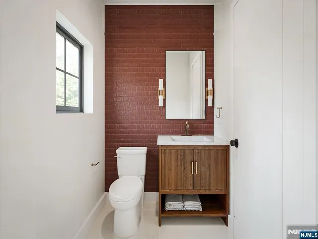 a bathroom with a toilet a sink and mirror