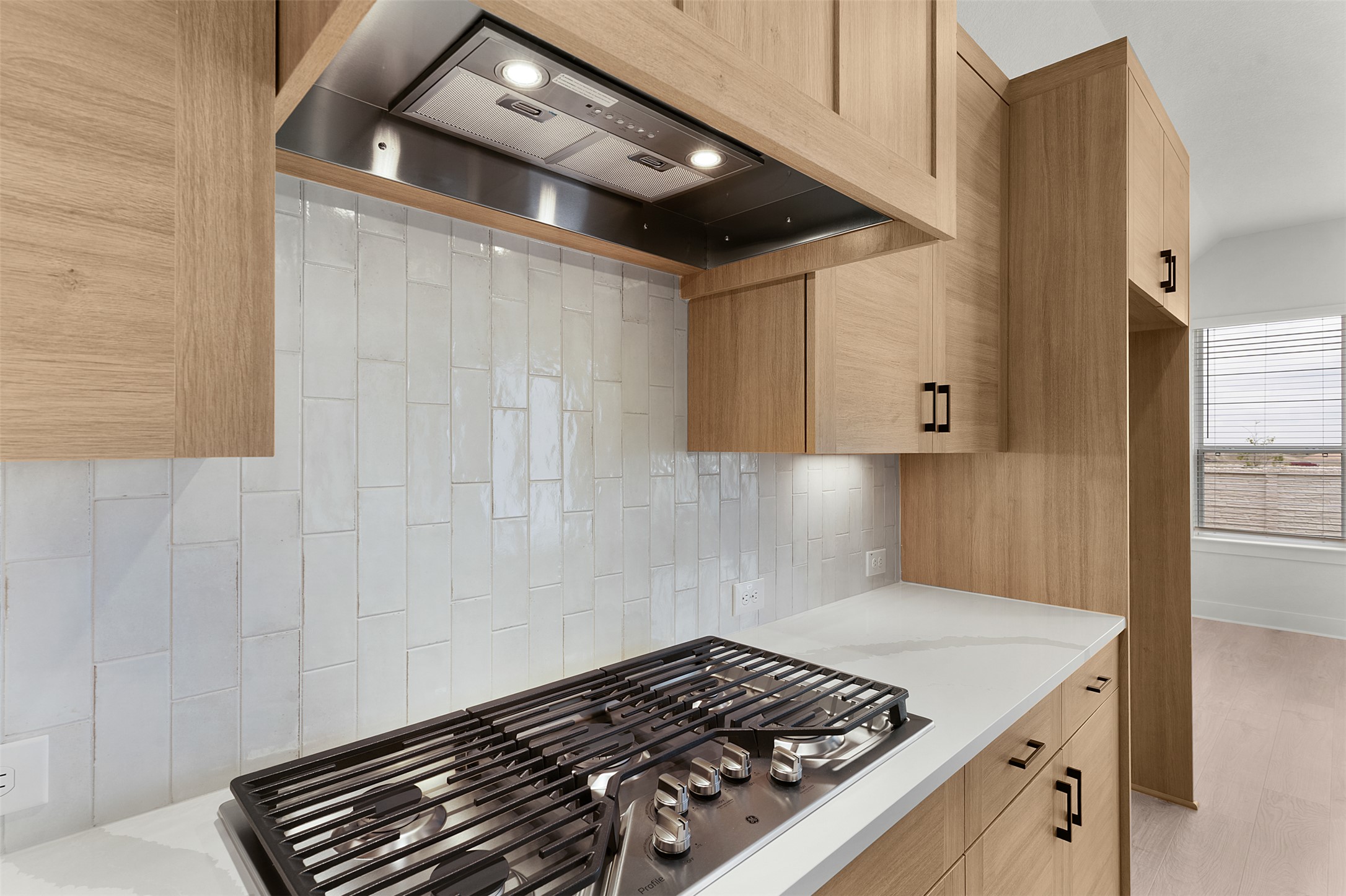 17316 Hope Bergman Road Pflugerville, TX 78660 - Photo 14 of 39 Kitchen with premium range hood, stainless steel gas cooktop, decorative backsplash, and light stone counters