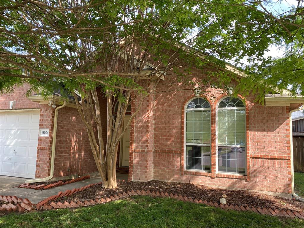 front view of a house with a tree in a yard