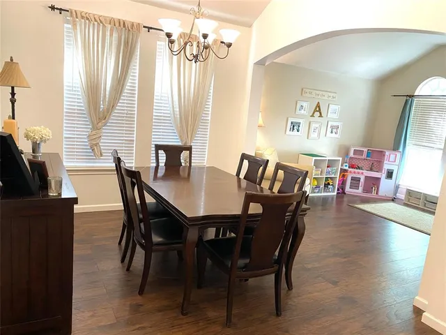 a dining room with furniture and view of kitchen