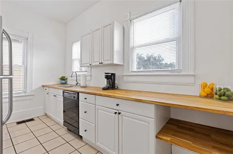 a kitchen with white cabinets and window