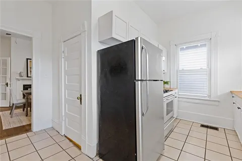 a view of a kitchen with white cabinets and refrigerator